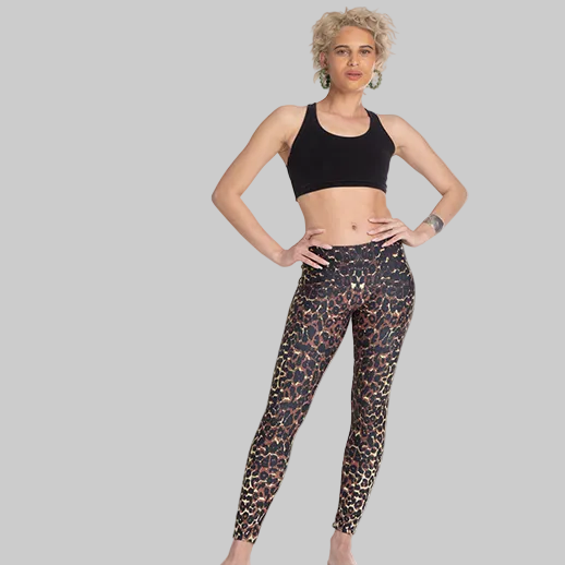 Woman wearing black sports bra and leopard print leggings on a white background