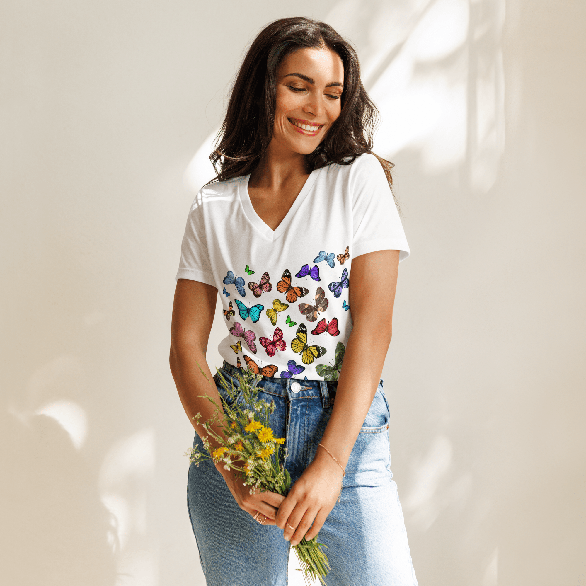 Woman  holding flowers and wearing Butterfly Collective Tee in white with multicolored butterflies